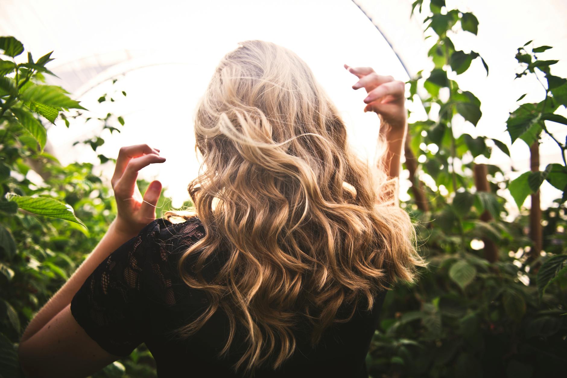 blonde haired woman standing between green plants Hair Health