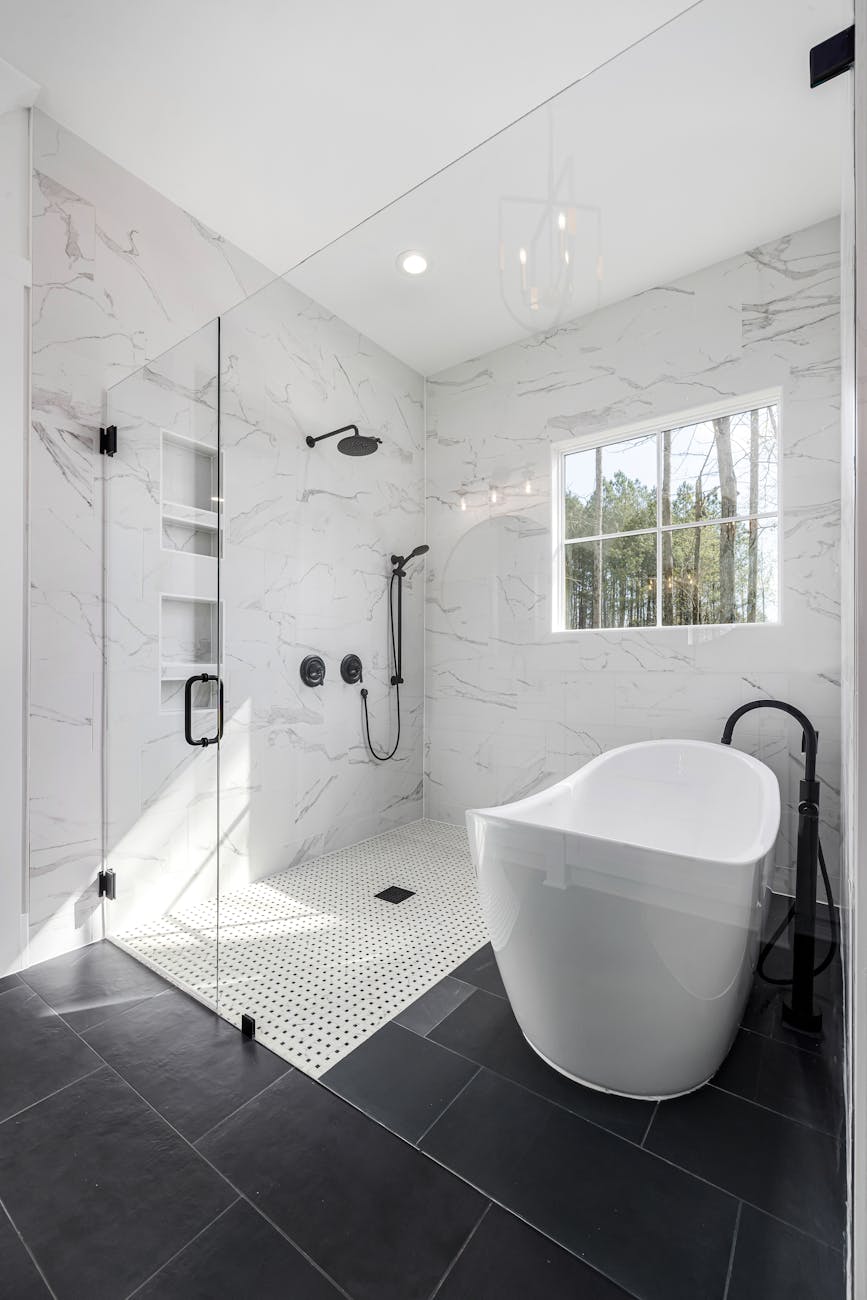 a bathroom with a large tub and black tile 7 Easy Home Upgrades to Enhance Your Listing
