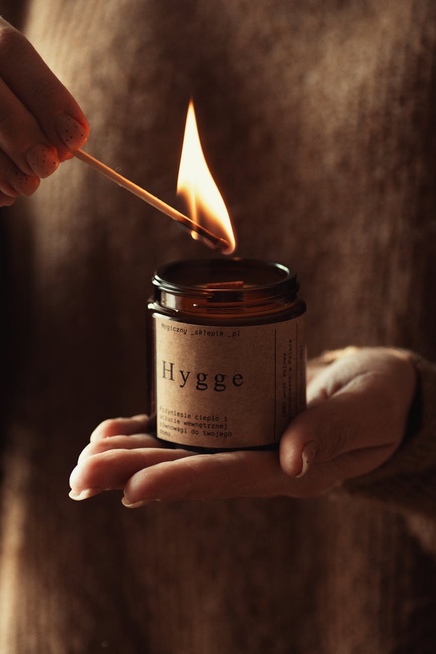 Hygge Home Design Ideas to Feed Your Mental Health 9 a person holding a candle with a flame hygge home design ideas to feed your mental health