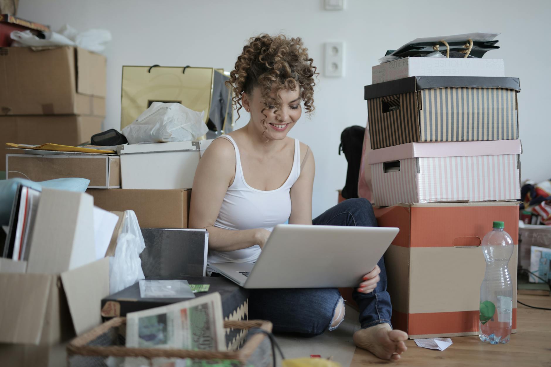 woman using laptop on the floor biggest sources of household clutter
