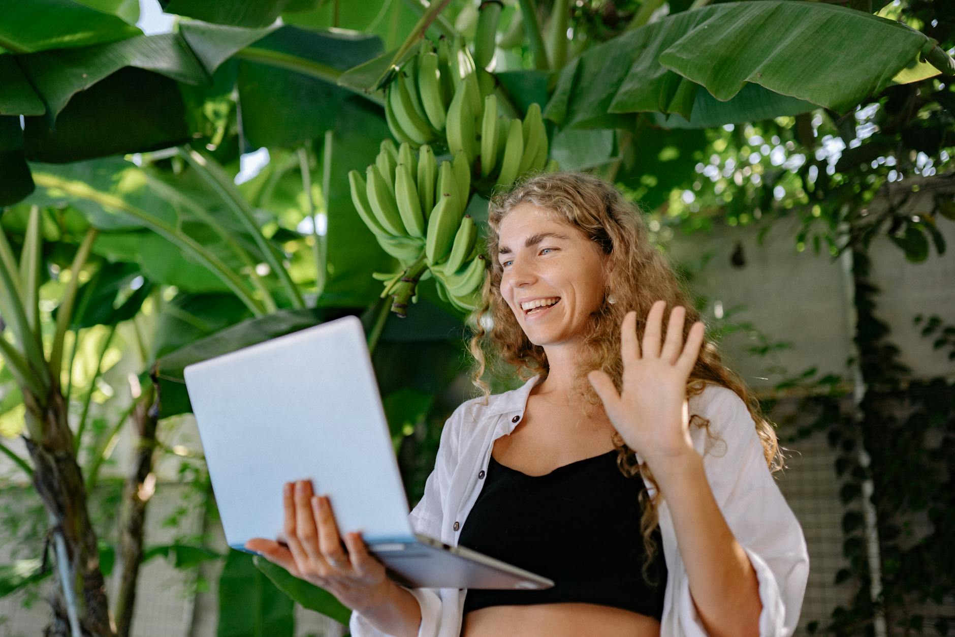 woman using a laptop near a banana tree Upgrade Your Zoom Meetings with an Eye-Catching Virtual Background