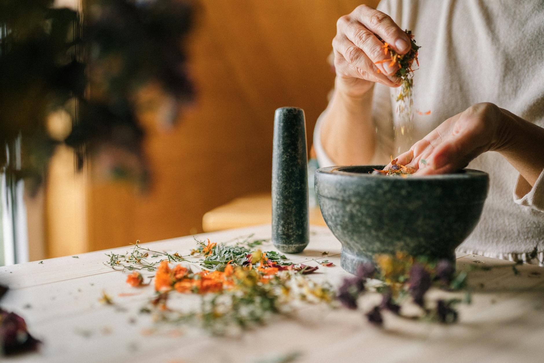 close up of woman grinding dry flowers in a mortar