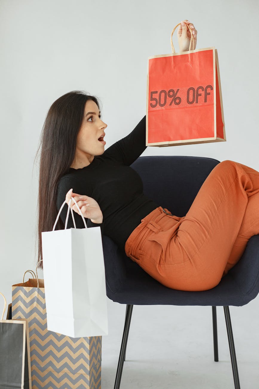 5 Money Saving Tips to Protect Household Finances 8 woman sitting on a chair and holding shopping bags from sale 5 Money Saving Tips to Protect Household Finances