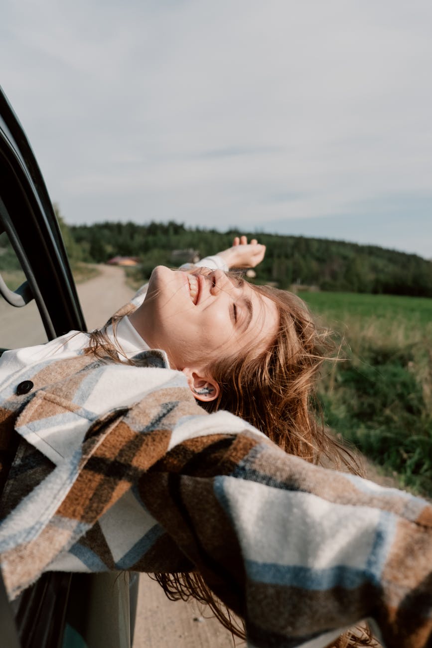 The Biggest Life Milestones You Will Experience in Adulthood 7 woman in plaid coat leaning out the car window The Biggest Life Milestones You Will Experience in Adulthood