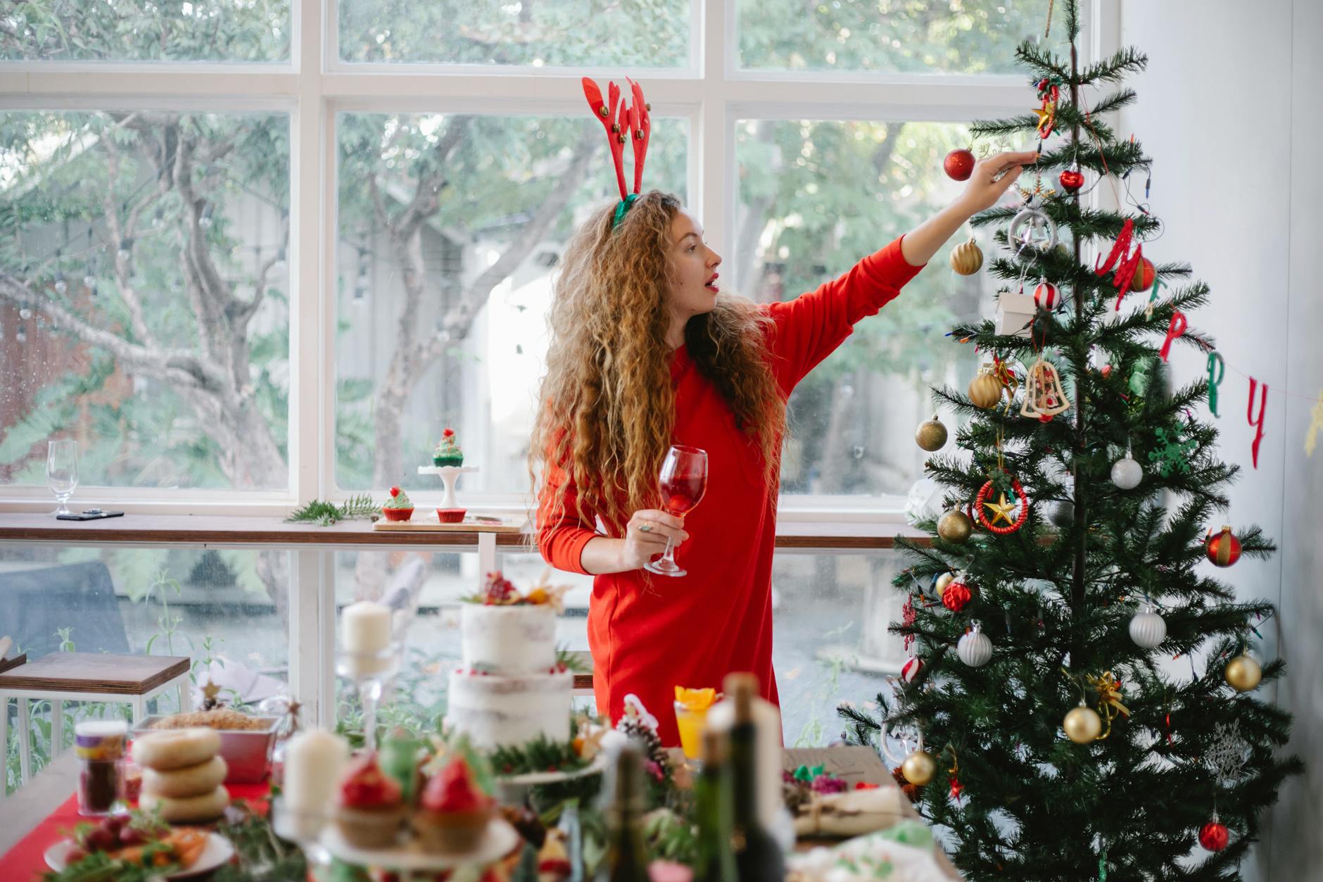 woman in headband with reindeer decorating christmas tree The Benefits of Rotating Seasonal Items into Storage