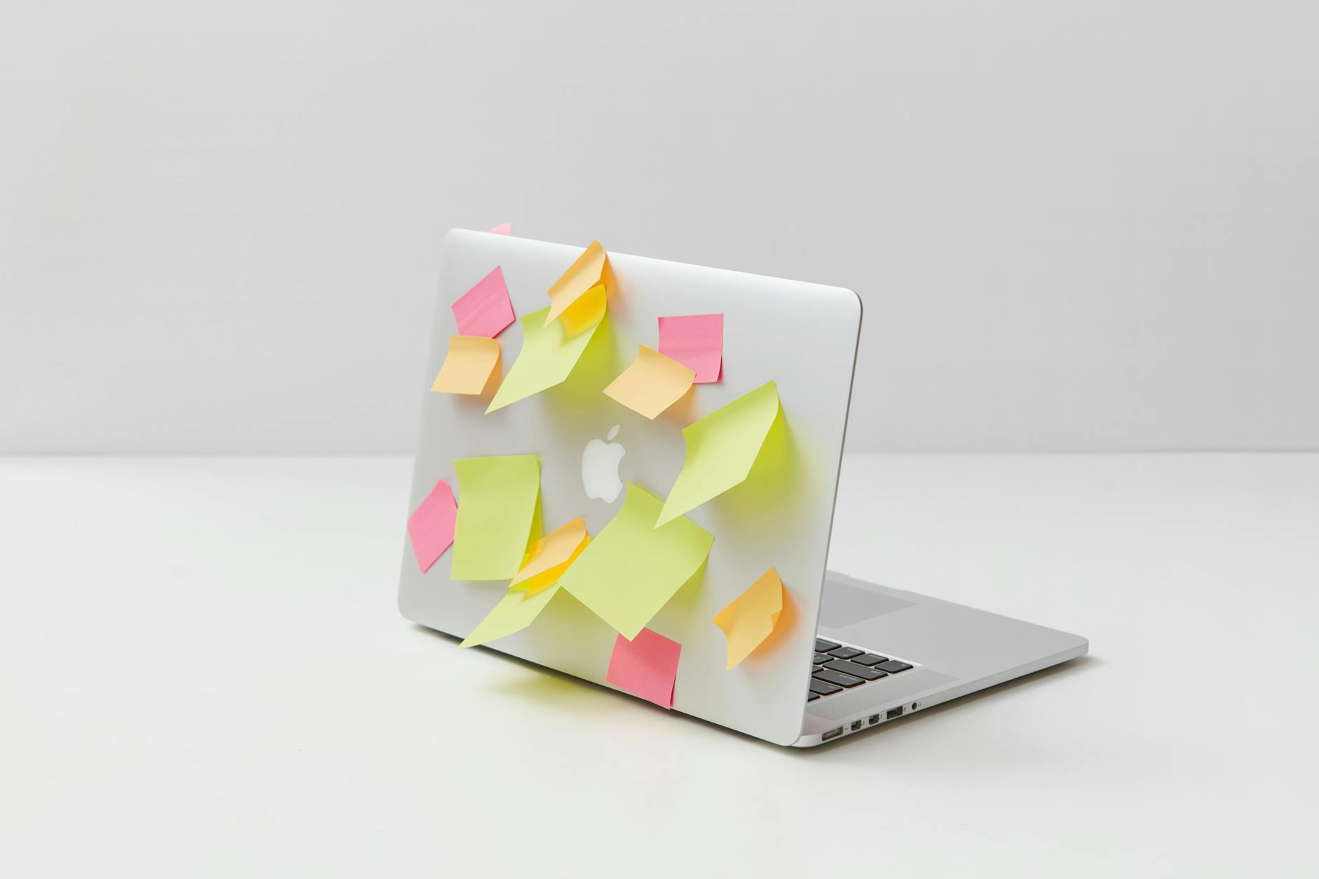 yellow green and pink sticky notes on silver laptop Top 7 Biggest Sources of Household Clutter (and how to fix them!)