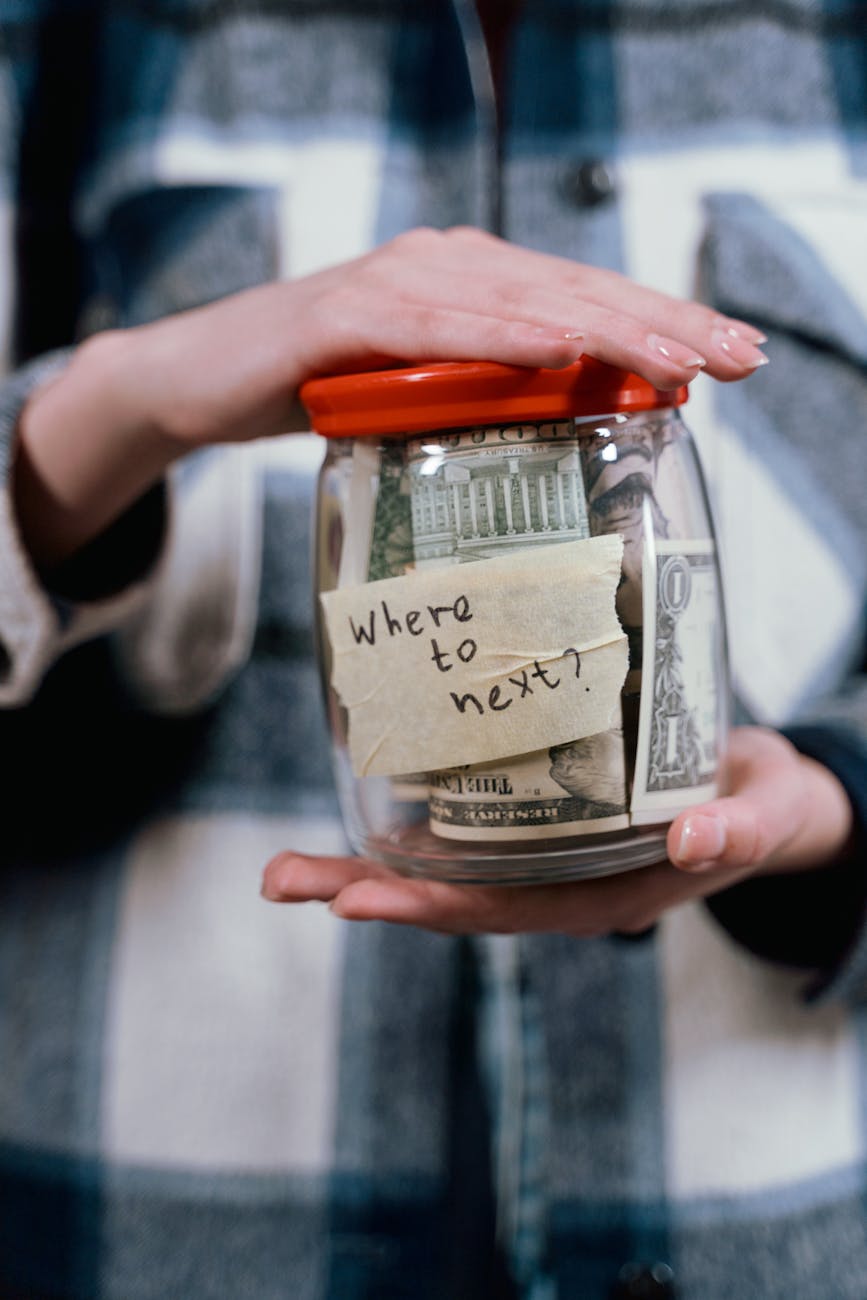 a person holding a container full of money The Ultimate Guide to Financial Independence