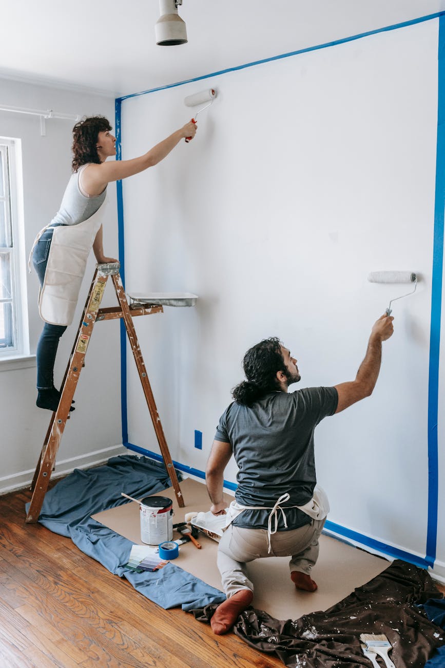 a couple painting the wall 7 Easy Home Upgrades to Enhance Your Listing