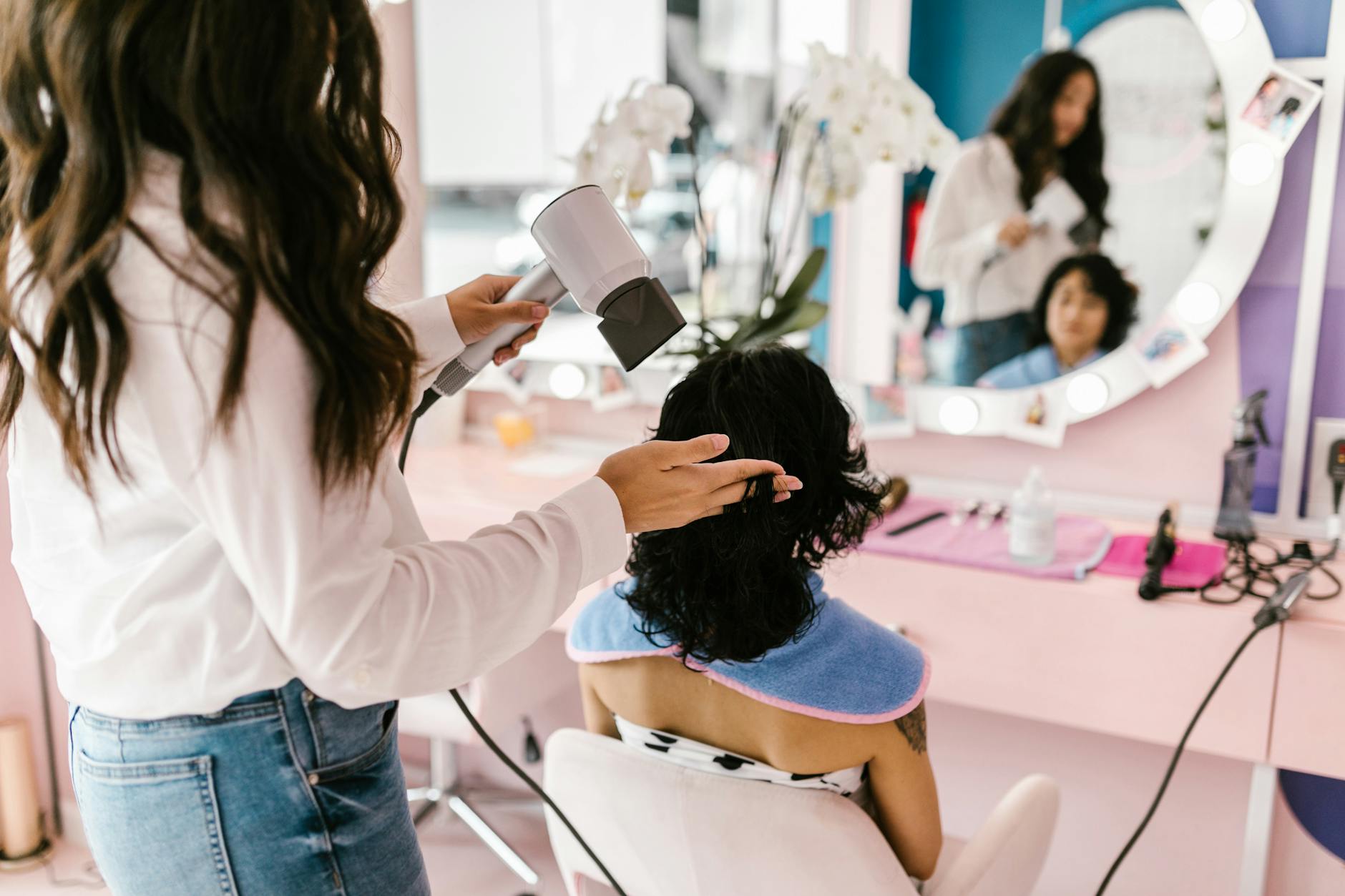 a person getting a blow dry at a hair salon Why Stress is Sabotaging Your Hair Health