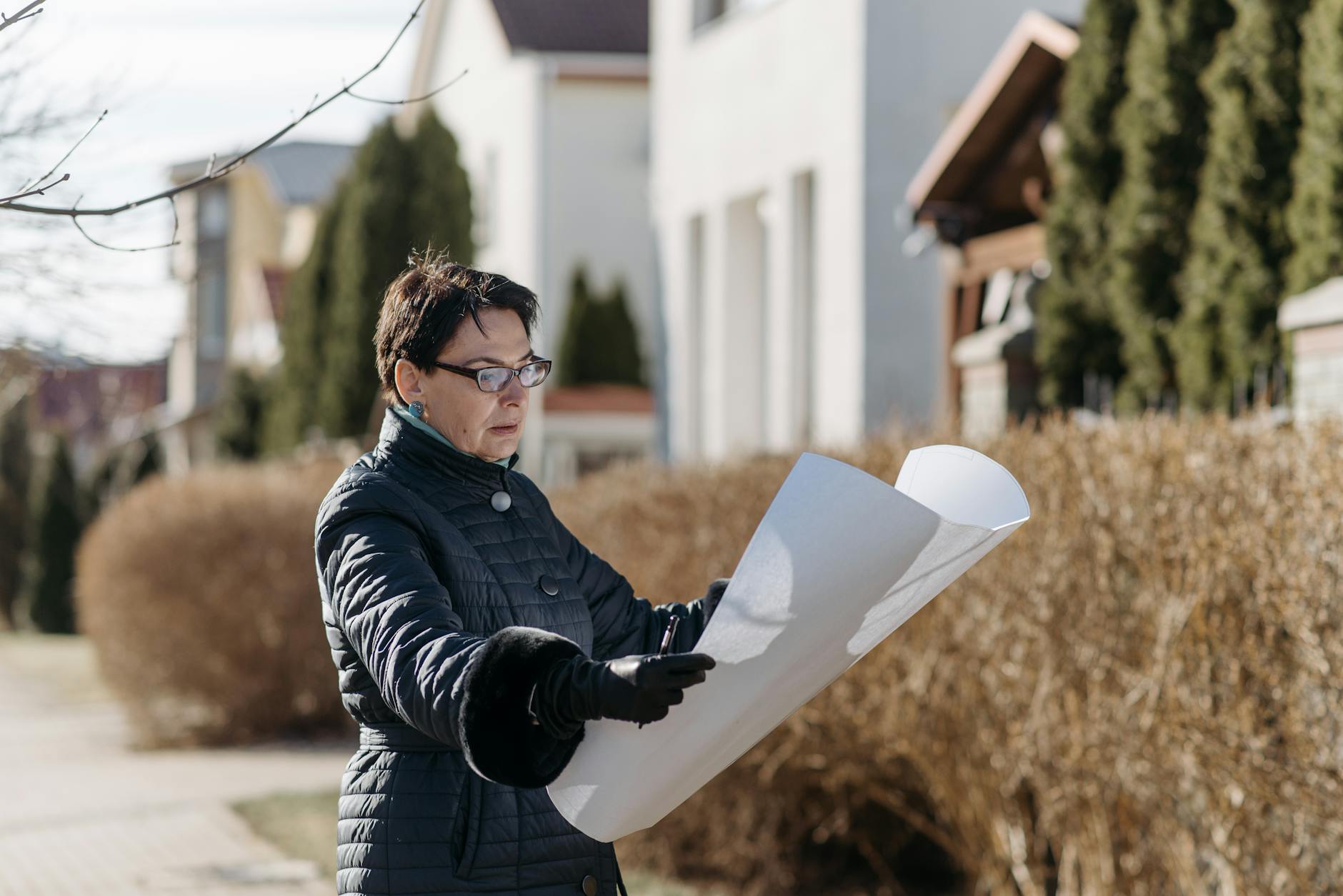 woman in black jacket holding white paper