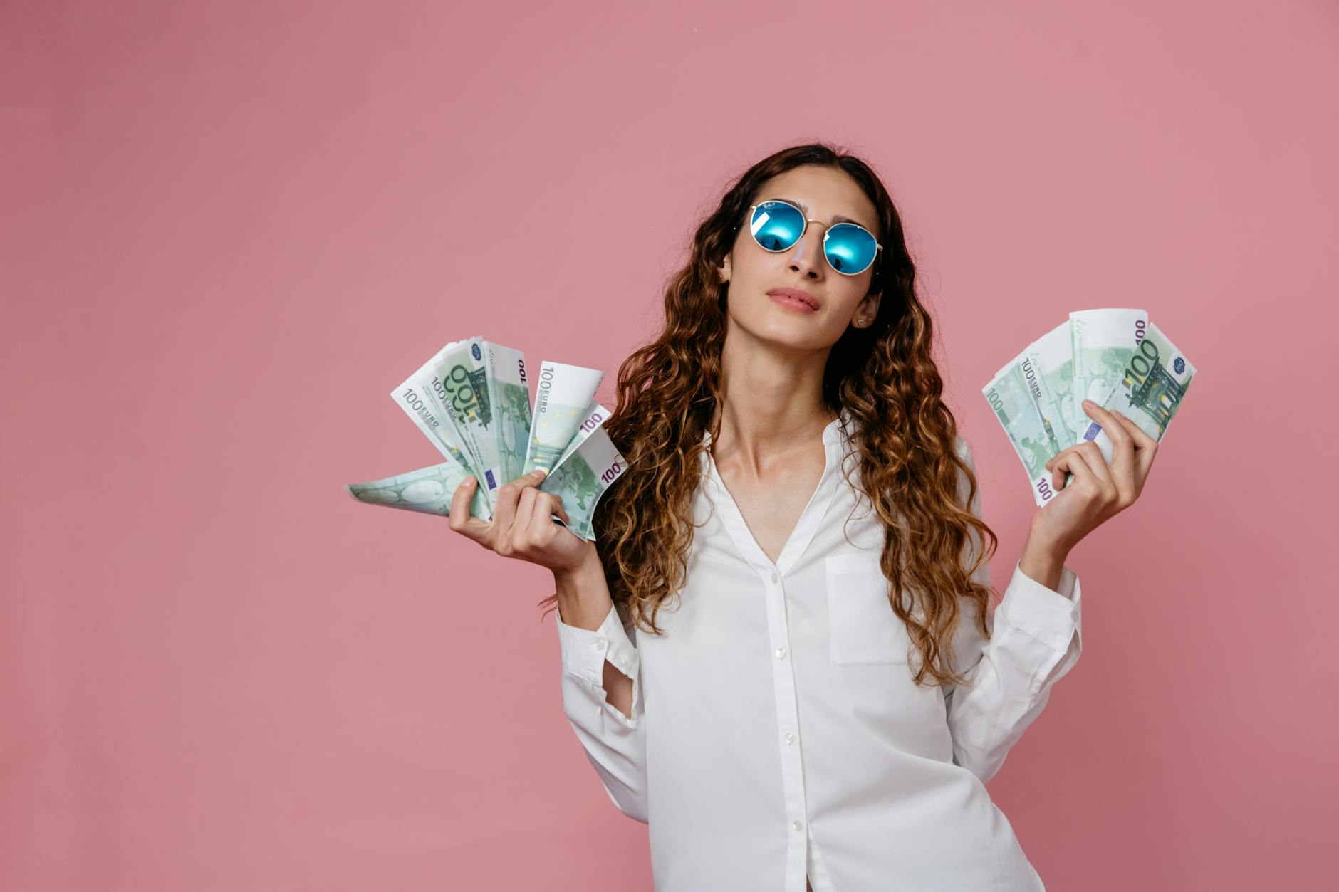 a woman in white long sleeve button up shirt holding bank notes