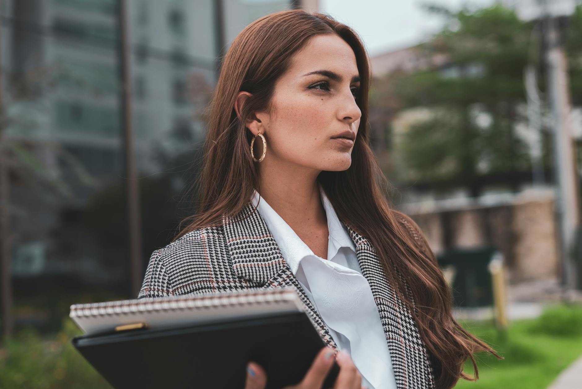confident businesswoman standing outside building