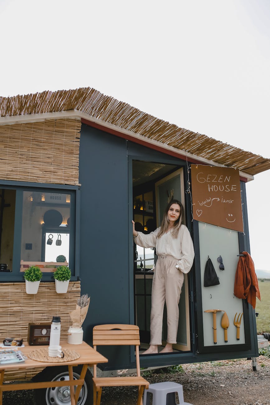 woman standing in a trailer converted to a house on wheels Why Building Your Own Home Is Achievable and Affordable