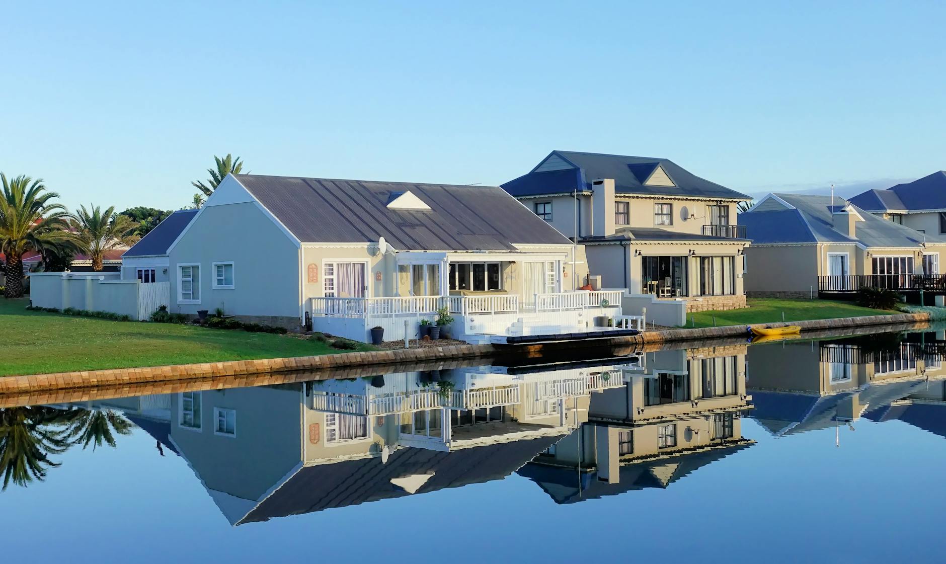 white single story houses beside body of water Expert Tips for Buying Your Next Home or Investment Property