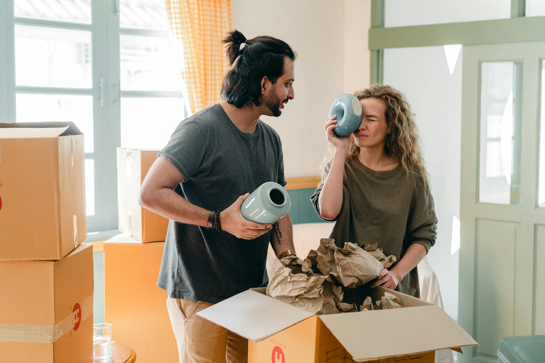 Moving House? Here’s How to Make Things Less Stressful 10 multi ethnic couple with ceramic vases and pile of cardboard boxes Moving House? Here’s How to Make Things Less Stressful