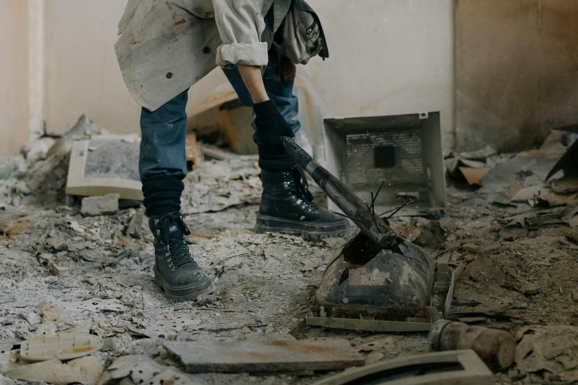 person in blue denim jeans and black leather boots standing beside black metal machine Why Building Your Own Home Is Achievable and Affordable