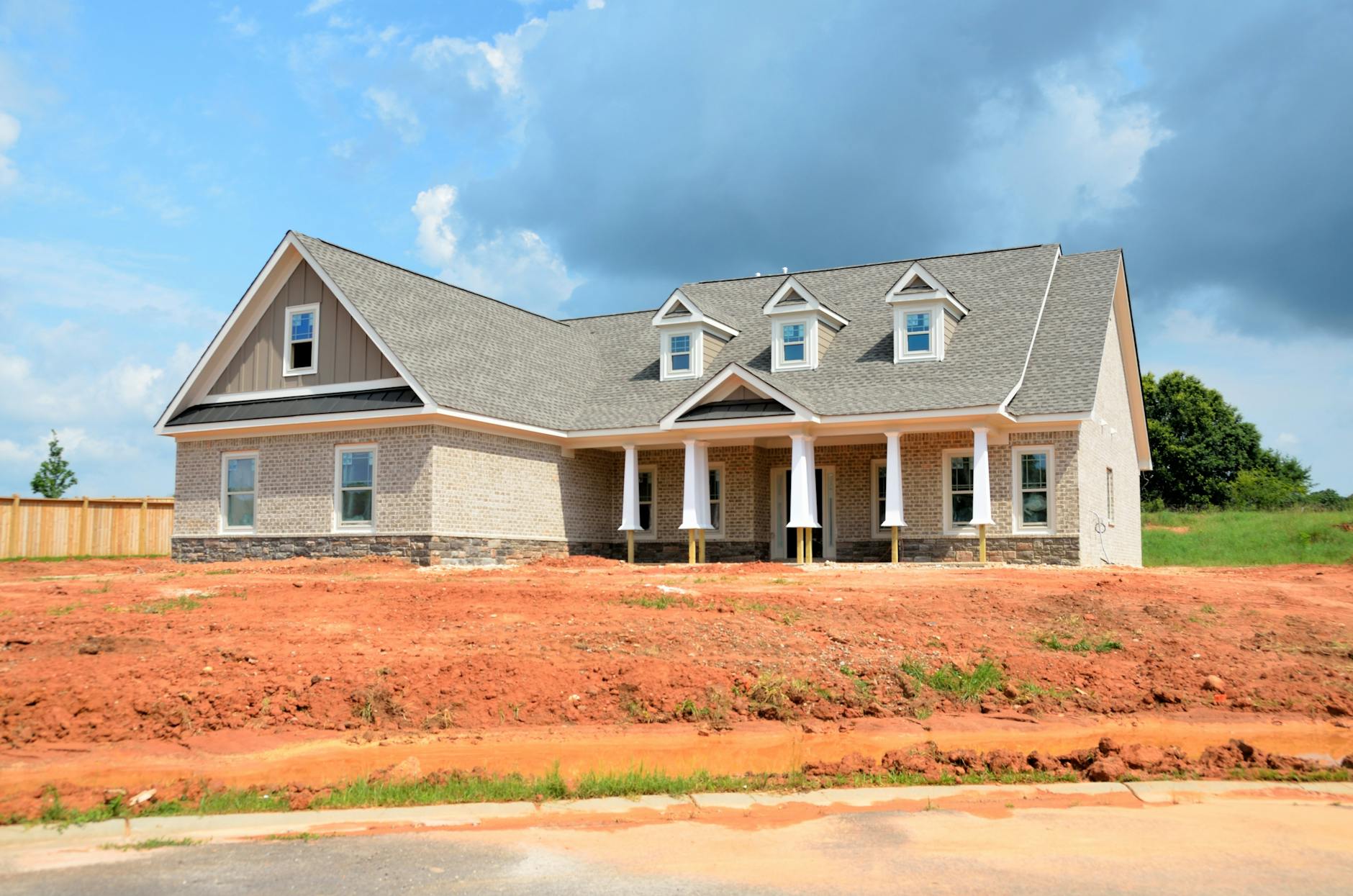 gray bungalow house under blue and white cloudy sky Why Building Your Own Home Is Achievable and Affordable