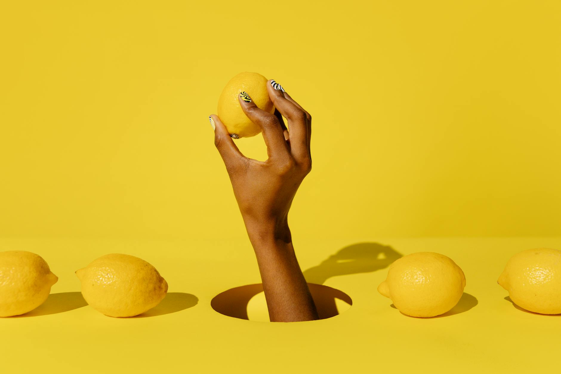 a hand holding a lemon