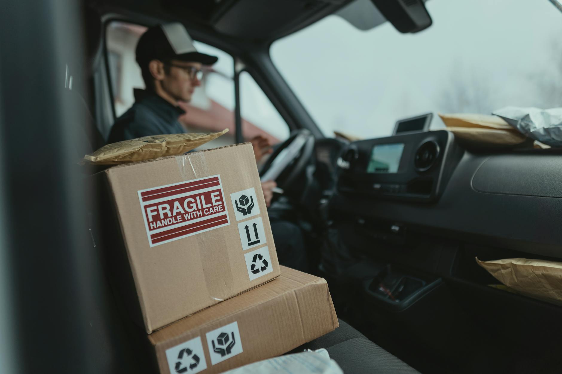 brown carton boxes inside a car Why Fuel Costs Are The Most Important Expense For Your Fleet Business
