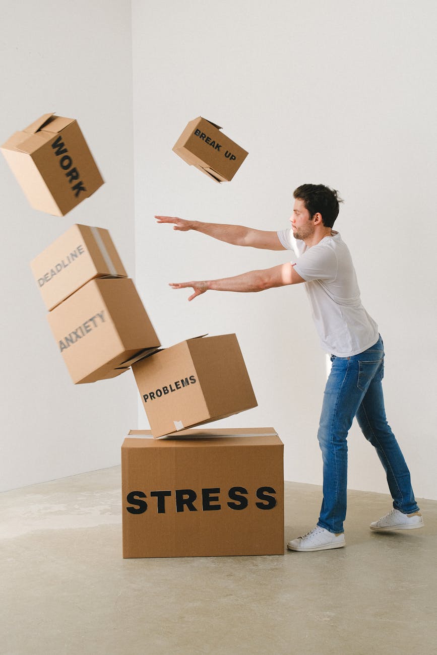 man falling carton boxes with negative words How to Survive When You're Struggling Financially