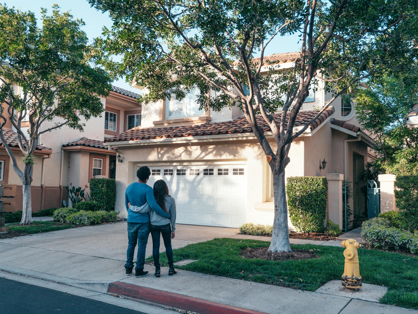 couple standing in front of their house Expert Tips for Buying Your Next Home or Investment Property