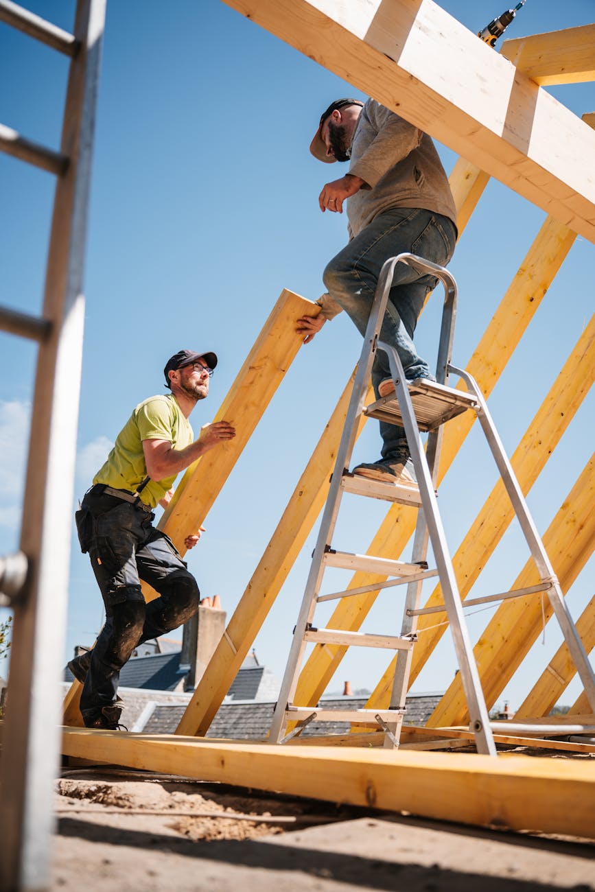roof construction with wooden framework and workers Home Fixes You'll Want To Hire A Pro For