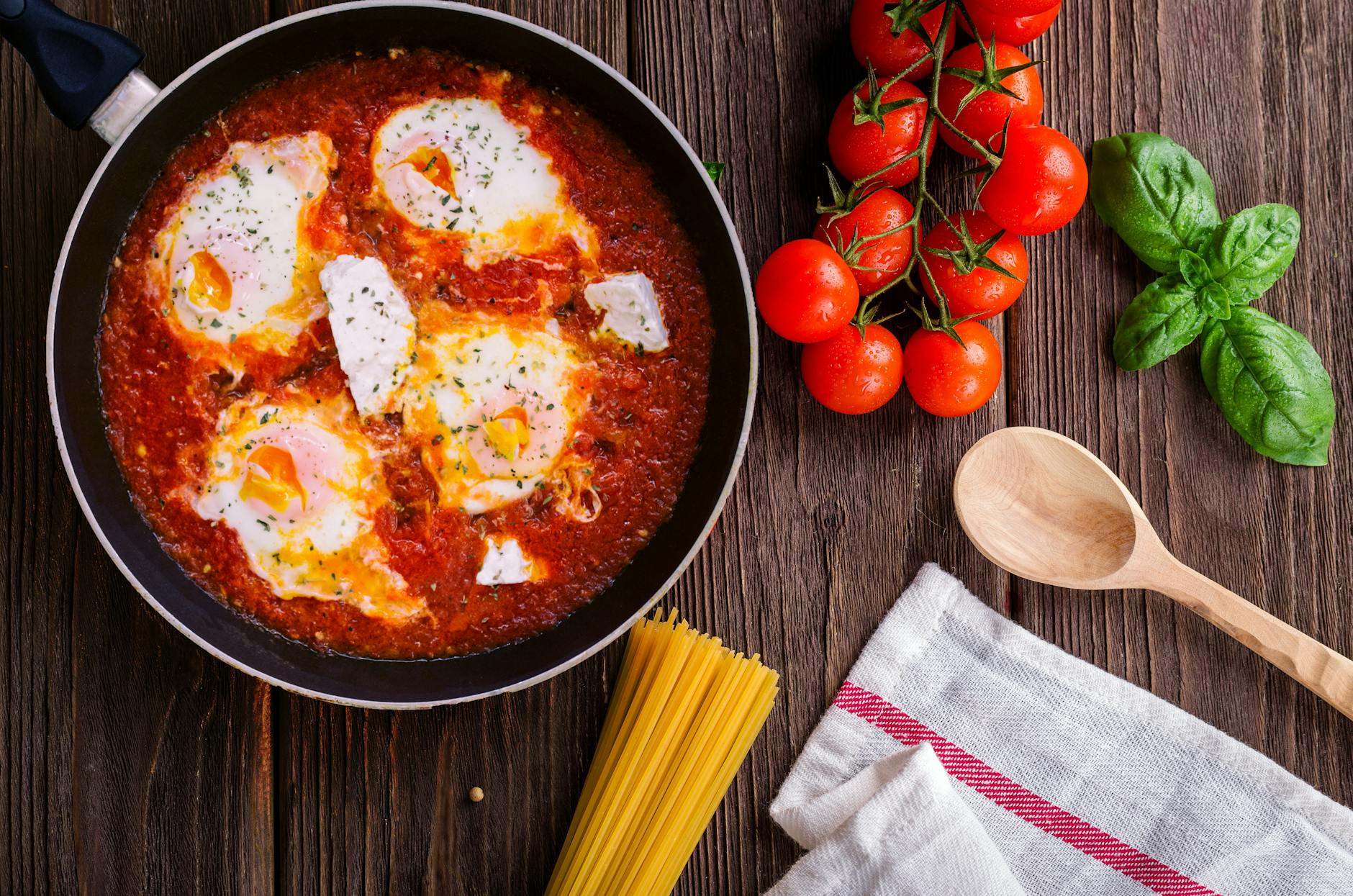4 Easy Ways to Build Flavor in Home Cooking (Without Overcomplicating Things) 12 black frying pan with spaghetti sauce near brown wooden ladle and ripe tomatoes 4 Easy Ways to Build Flavor in Home Cooking (Without Overcomplicating Things)