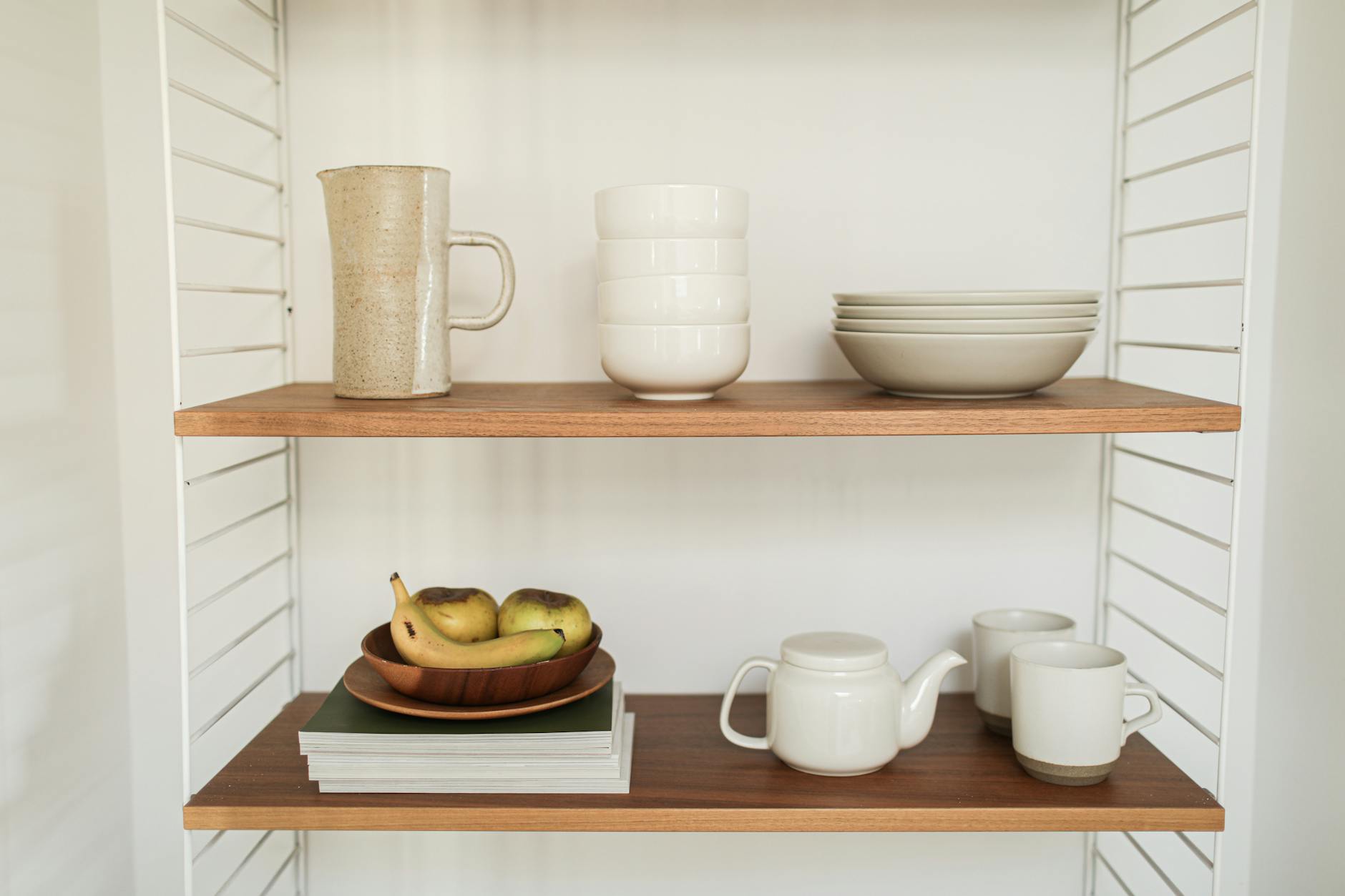 white ceramic tablewares on wooden shelf How to Set Up a Kitchen From Scratch: STR Hosts & New Homeowners