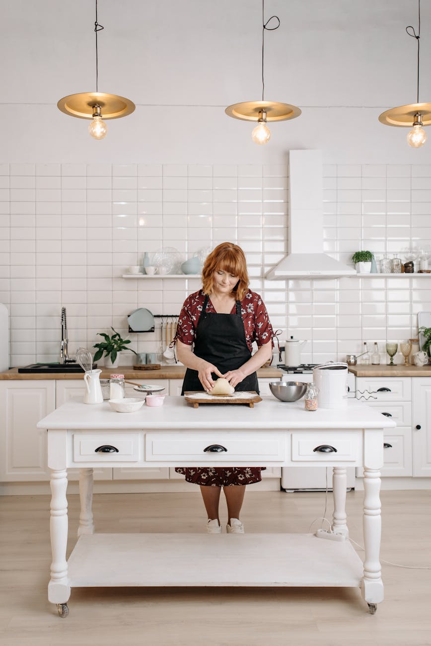a woman kneading a dough in a kitchen How to Set Up a Kitchen From Scratch: STR Hosts & New Homeowners