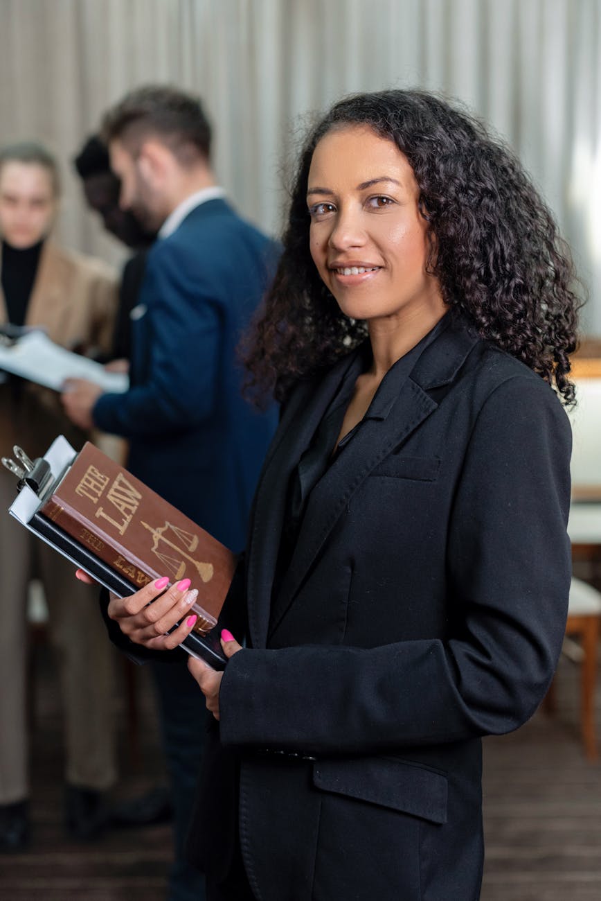 a woman in black blazer holding a law book 9 Times You Need A Lawyer In Your Life