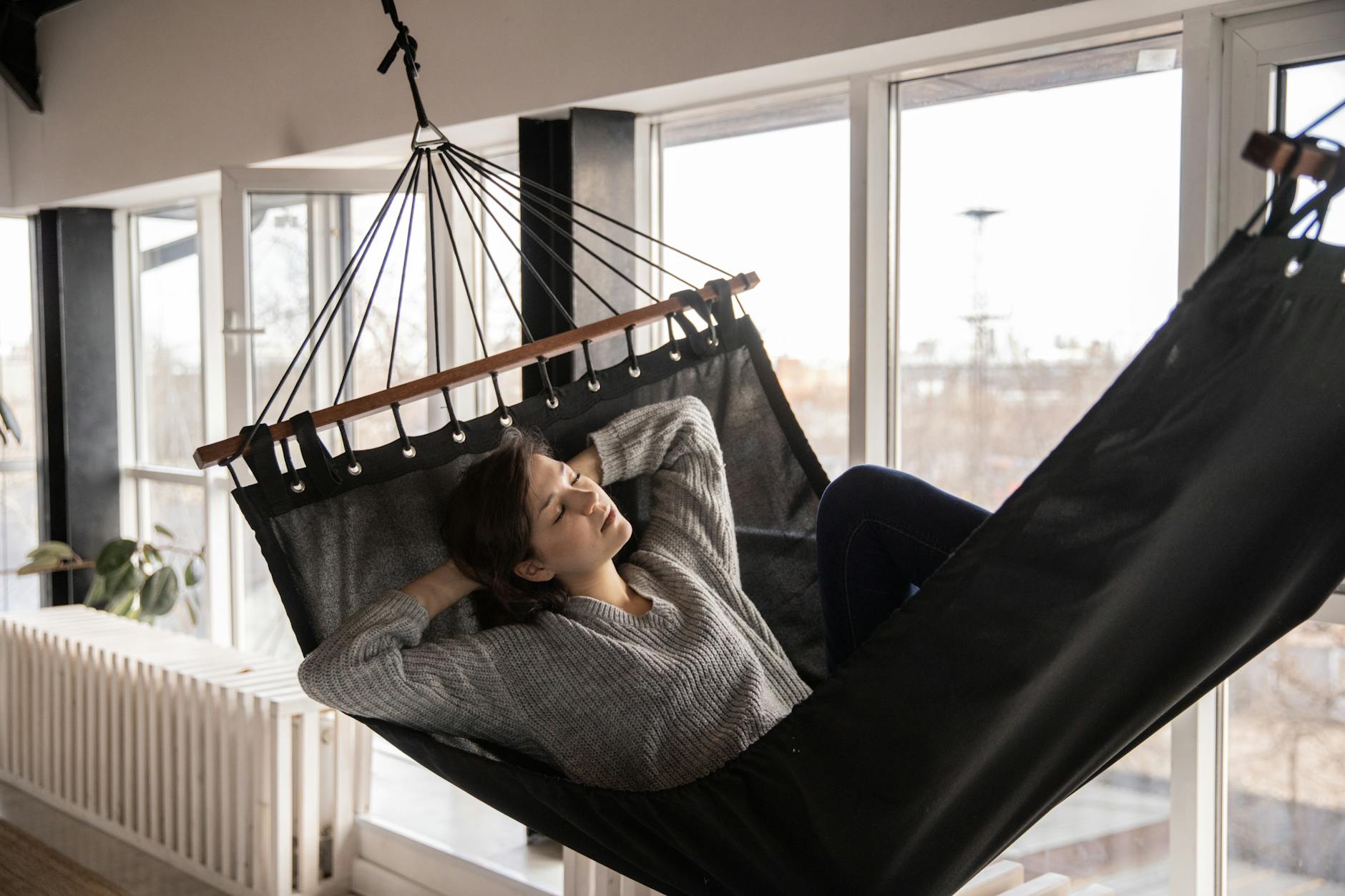 tired woman sleeping in cozy hammock in flat Why a Lazy Day is Good for Your Health