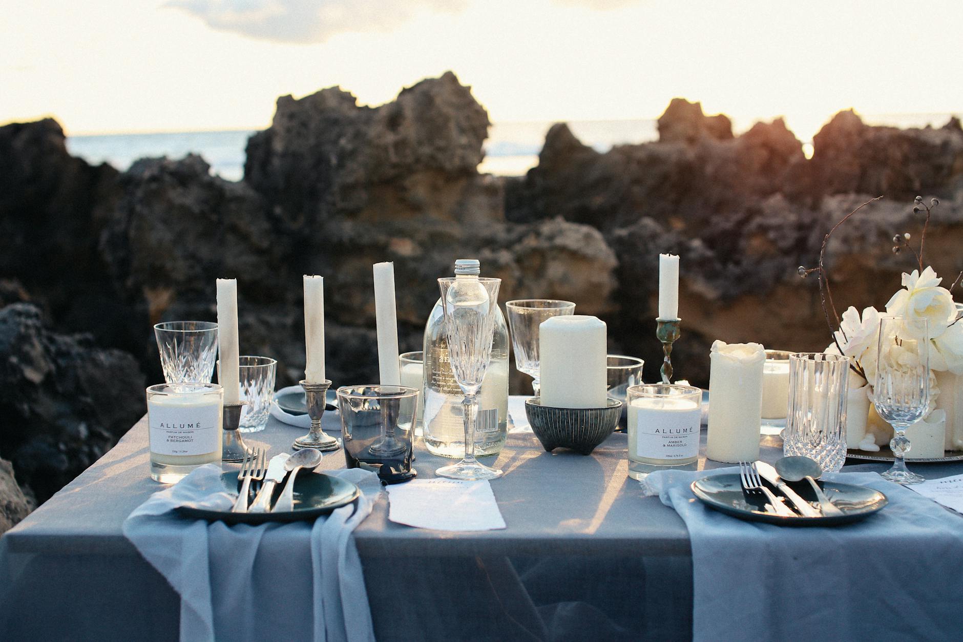 table setting with white pillar candles on table Luxurious Travel Activities to Add to Your Bucket List