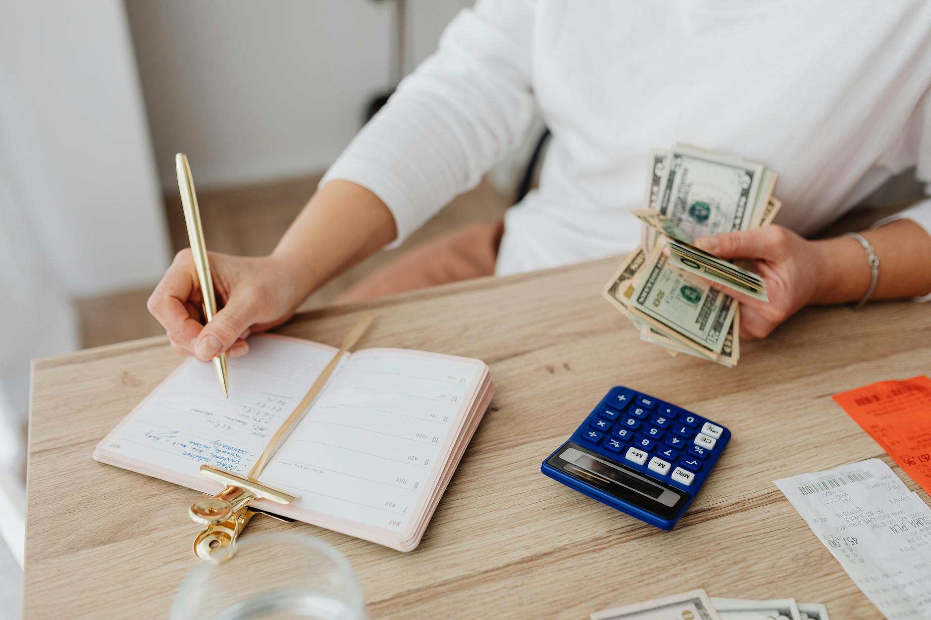 Budgeting for Shared Living: What to Expect and How to Split Costs 9 person writing on a notebook while holding money Budgeting for Shared Living: What to Expect and How to Split Costs