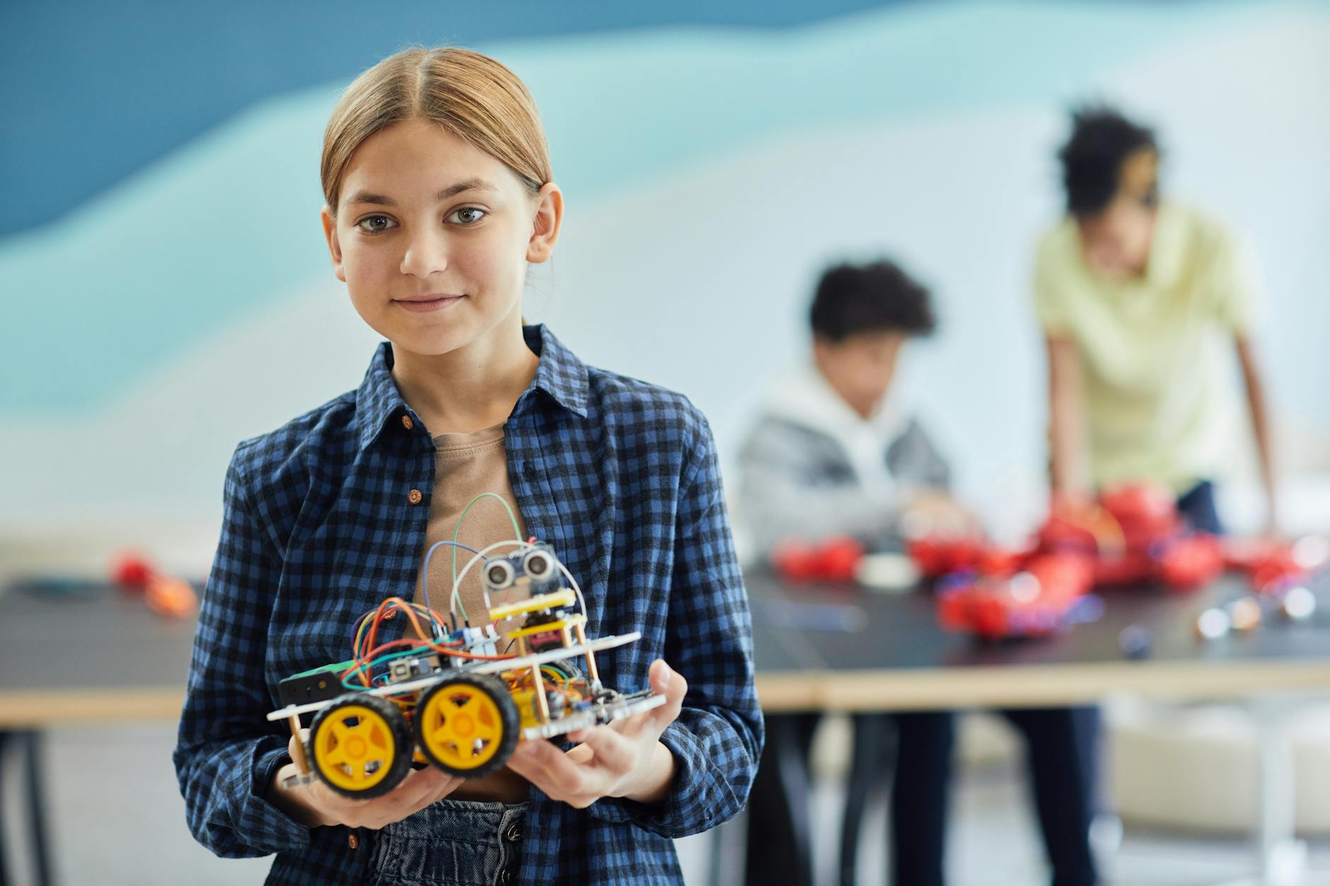 a girl in plaid long sleeves holding battery operated toy From Manicures to Multimeters: Rethinking What a Career Looks Like