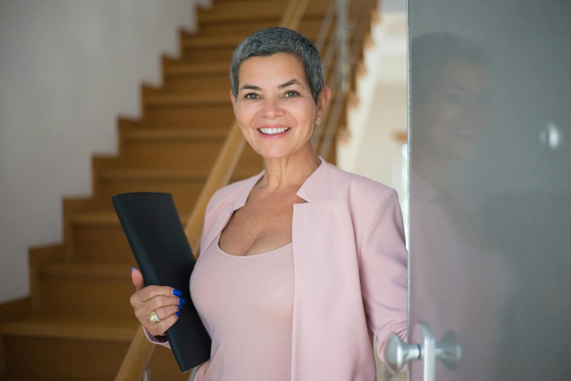 Rethinking Your Career Path? How to Start Working in Real Estate 13 an elderly woman holding a folder while standing on the doorway Rethinking Your Career Path? How to Start Working in Real Estate