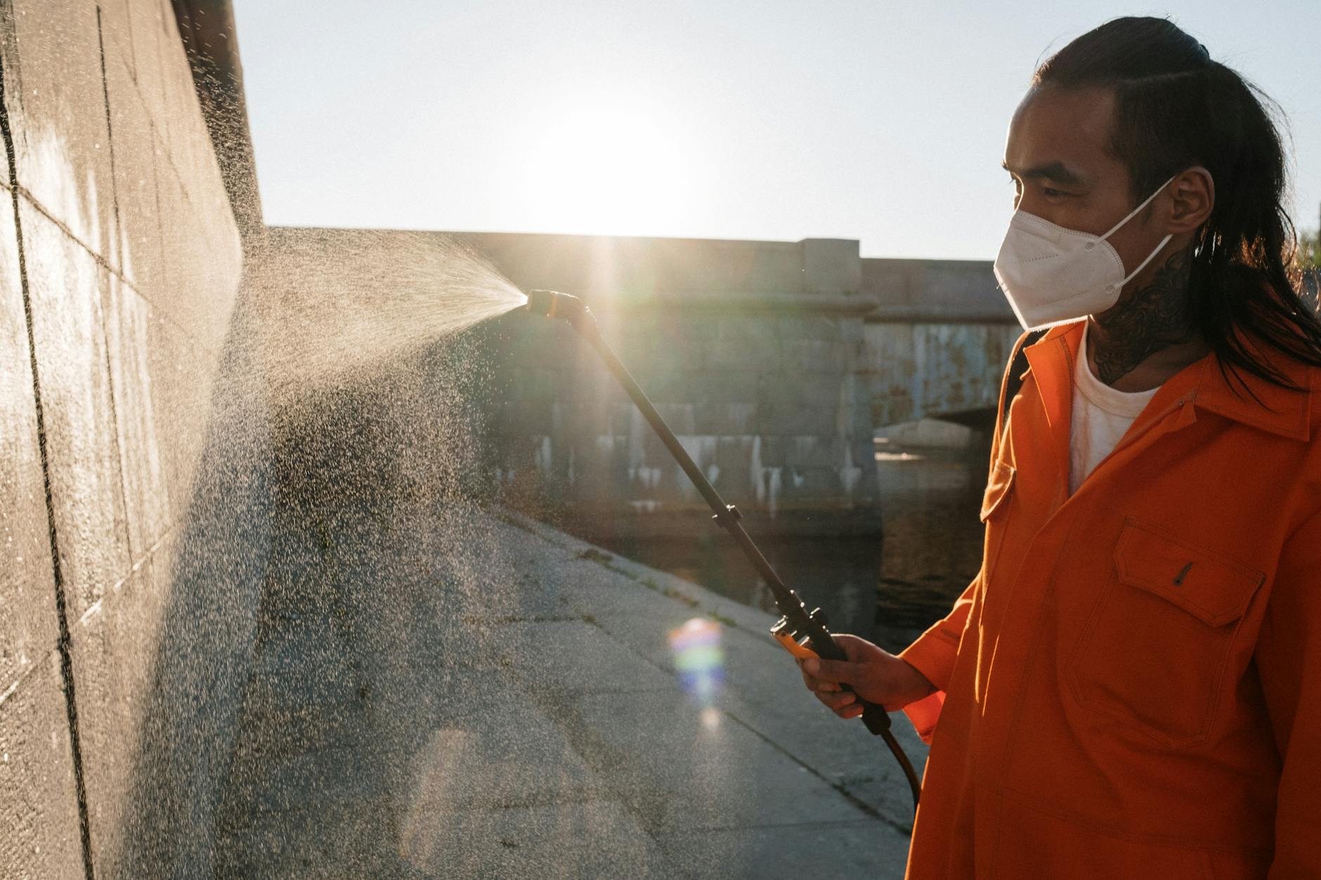 man in orange robe cleaning gray concrete wall 6 Ways Preventative Maintenance Saves Your Business Money
