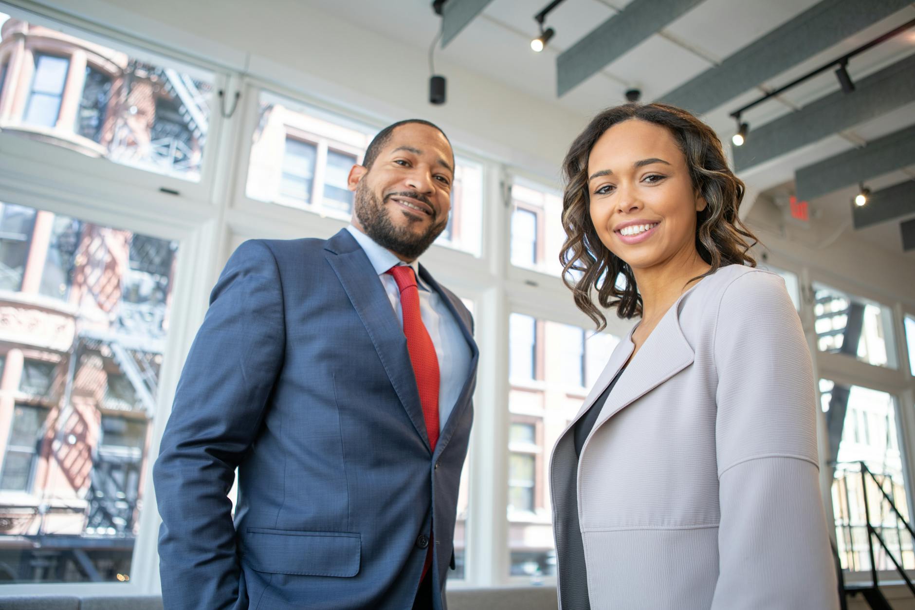 man and woman smiling inside building The Unexpected Skills That Can Increase Your Career Confidence