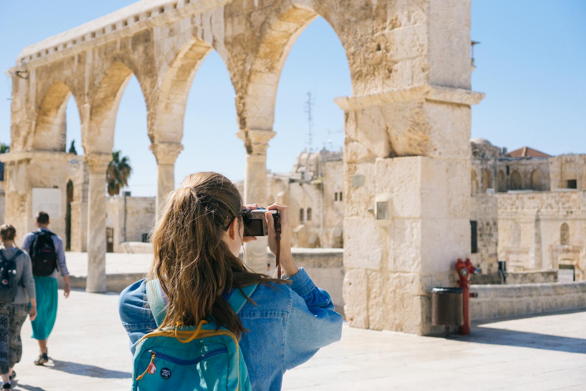 woman taking pictures of ruins Does a Travel Subscription Save You Money? (Plus How to Get Paid To Travel!)