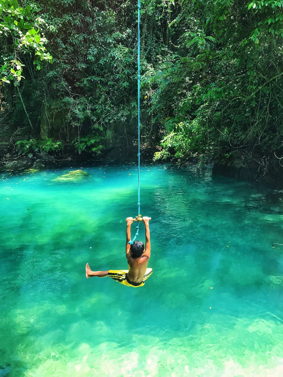 photo of boy swinging over body of water Does a Travel Subscription Save You Money? (Plus How to Get Paid To Travel!)