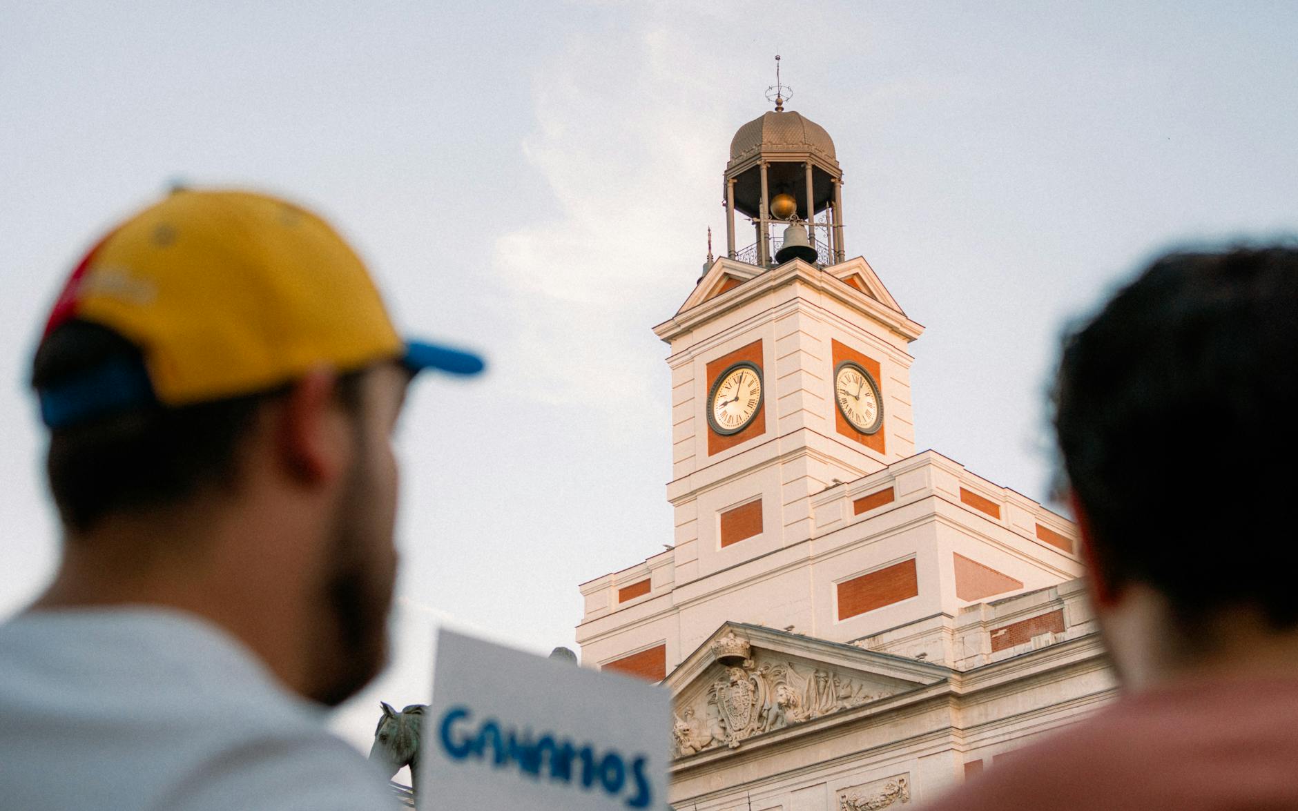 a group of people standing in front of a clock tower