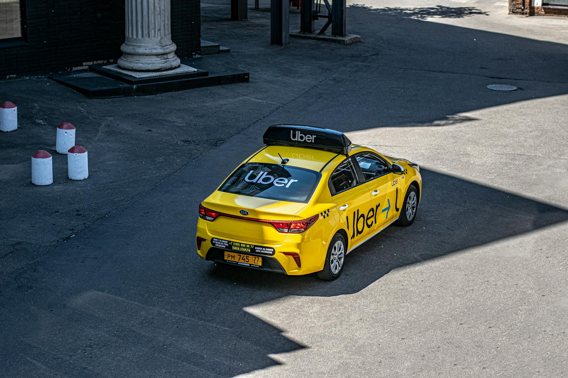 The Pros and Cons of Rideshare Services 8 yellow uber taxi on urban street The Pros and Cons of Rideshare Services