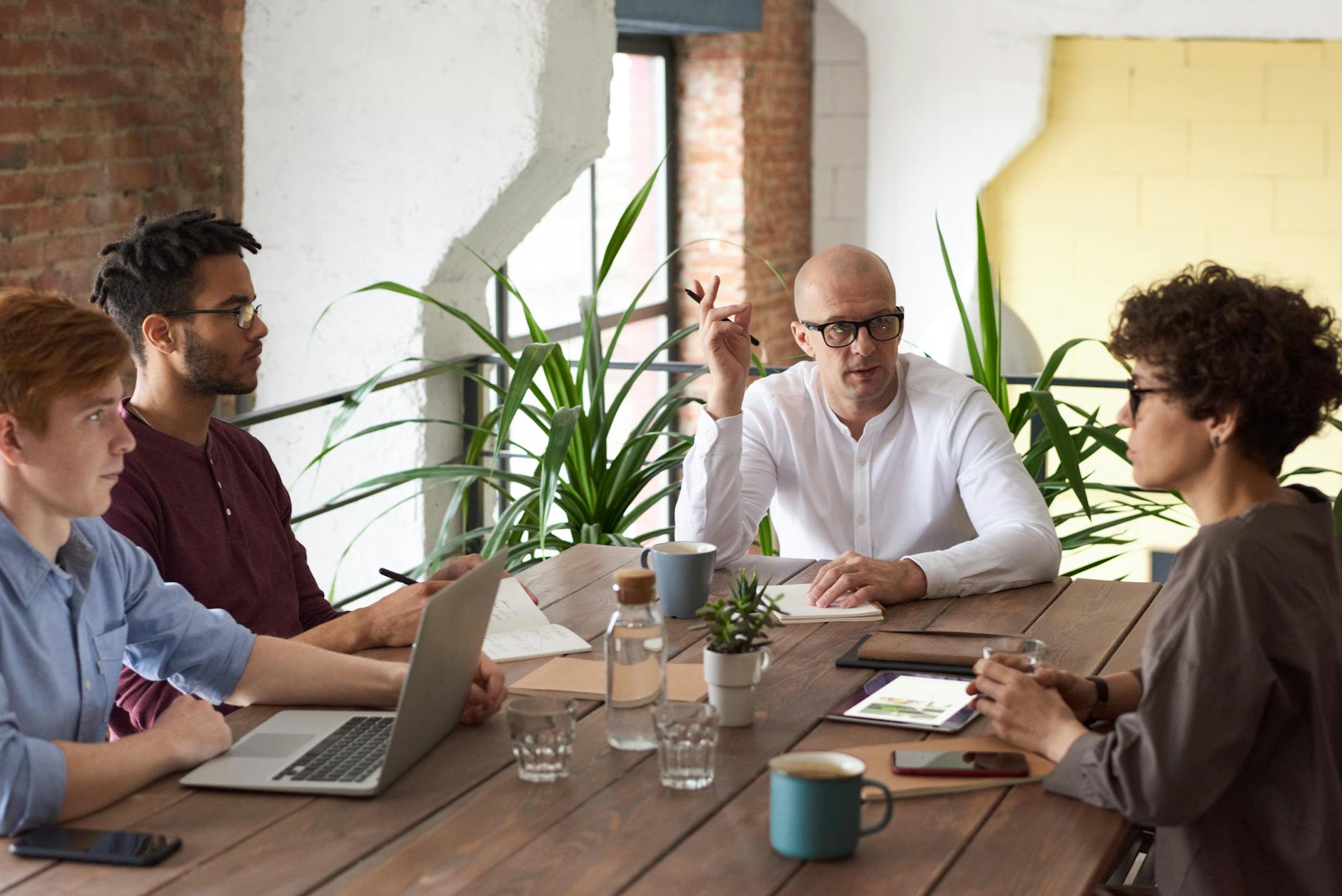man wearing white long sleeved shirt holding black pen Office Perks that Work for Every Generation on Your Team