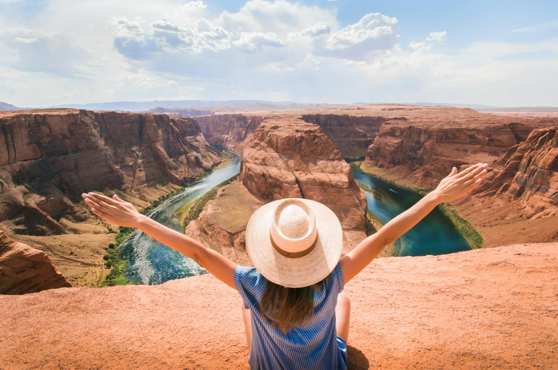 woman sitting on cliff overlooking mountain 5 Best Places to Buy Affordable Rural Land in the U.S. Reviewed 2025