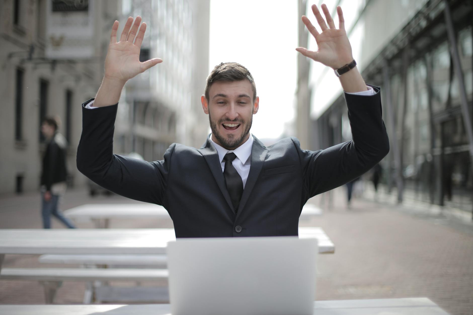 man in black suit raising both hands The Unexpected Skills That Can Increase Your Career Confidence