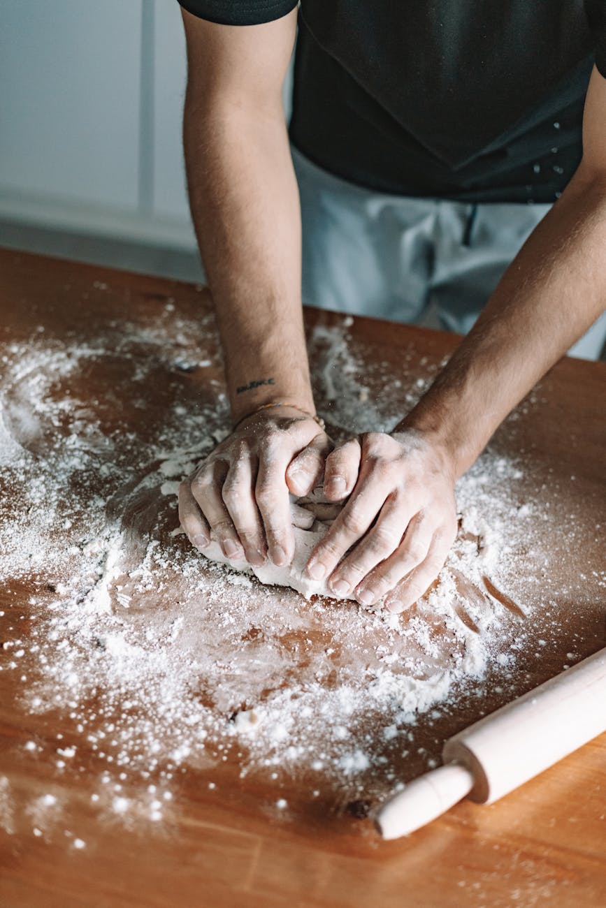 a person kneading a dough Why You Should Never Leave Crumbs On Your Kitchen Counter Overnight