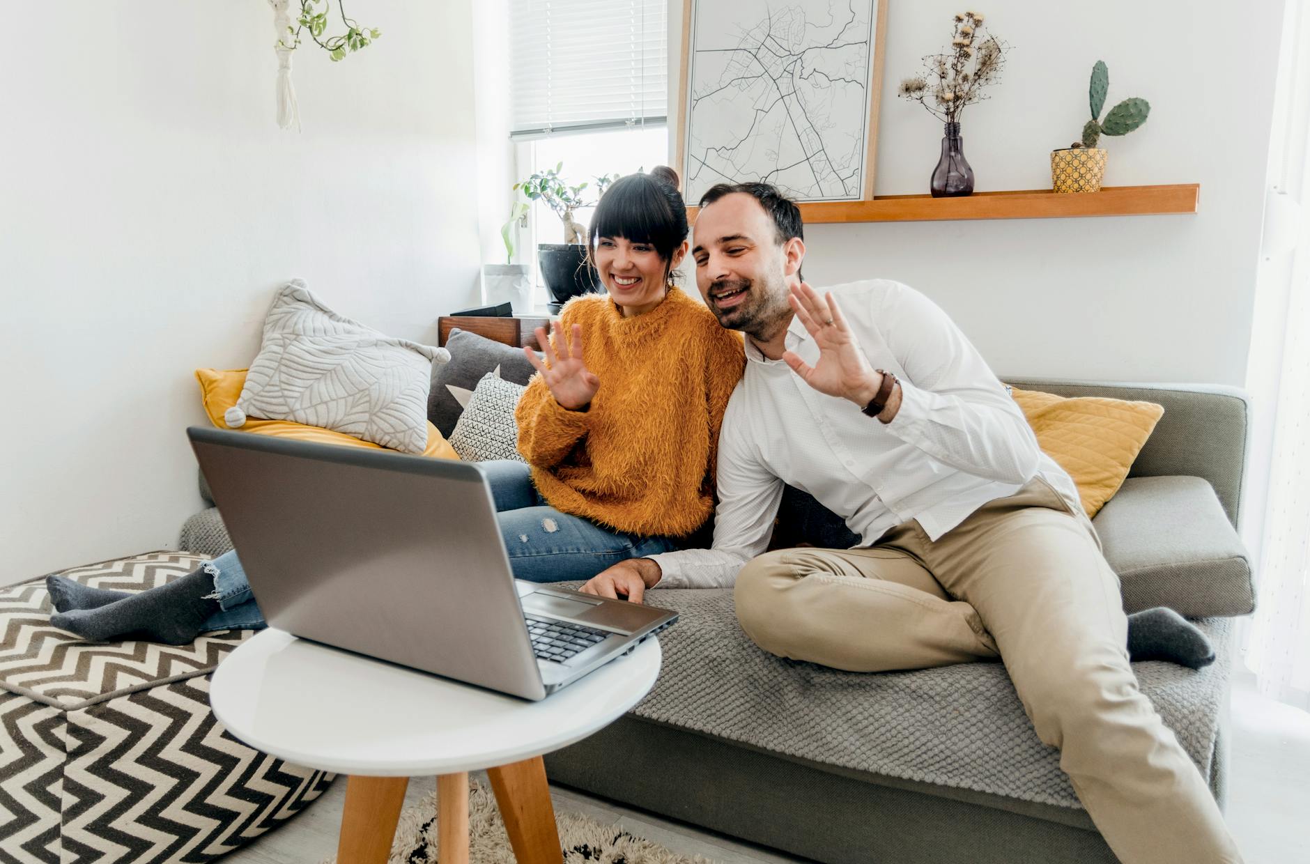 man in white long sleeves and woman in yellow fur long sleeves video calling on laptop