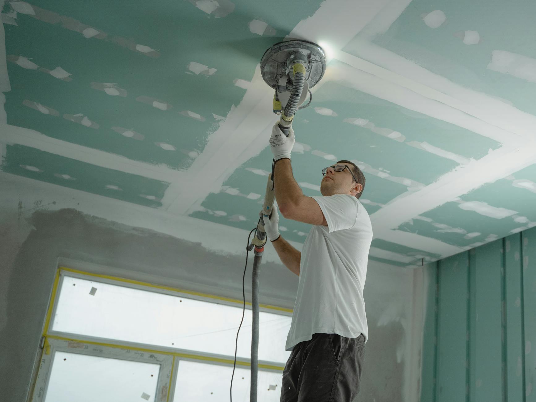 man polishing the ceiling 5 Practical Tips to Make Home Renovations Easier (and Less Stressful)