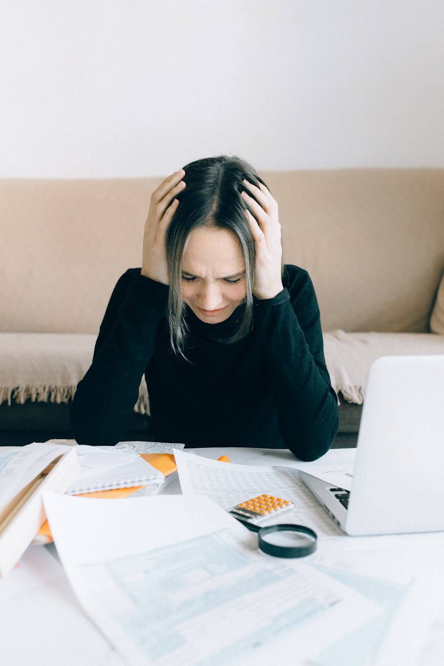 7 Foolproof Strategies to Tackle Your Financial Stress 14 exhausted woman holding her head 7 Foolproof Strategies to Tackle Your Financial Stress