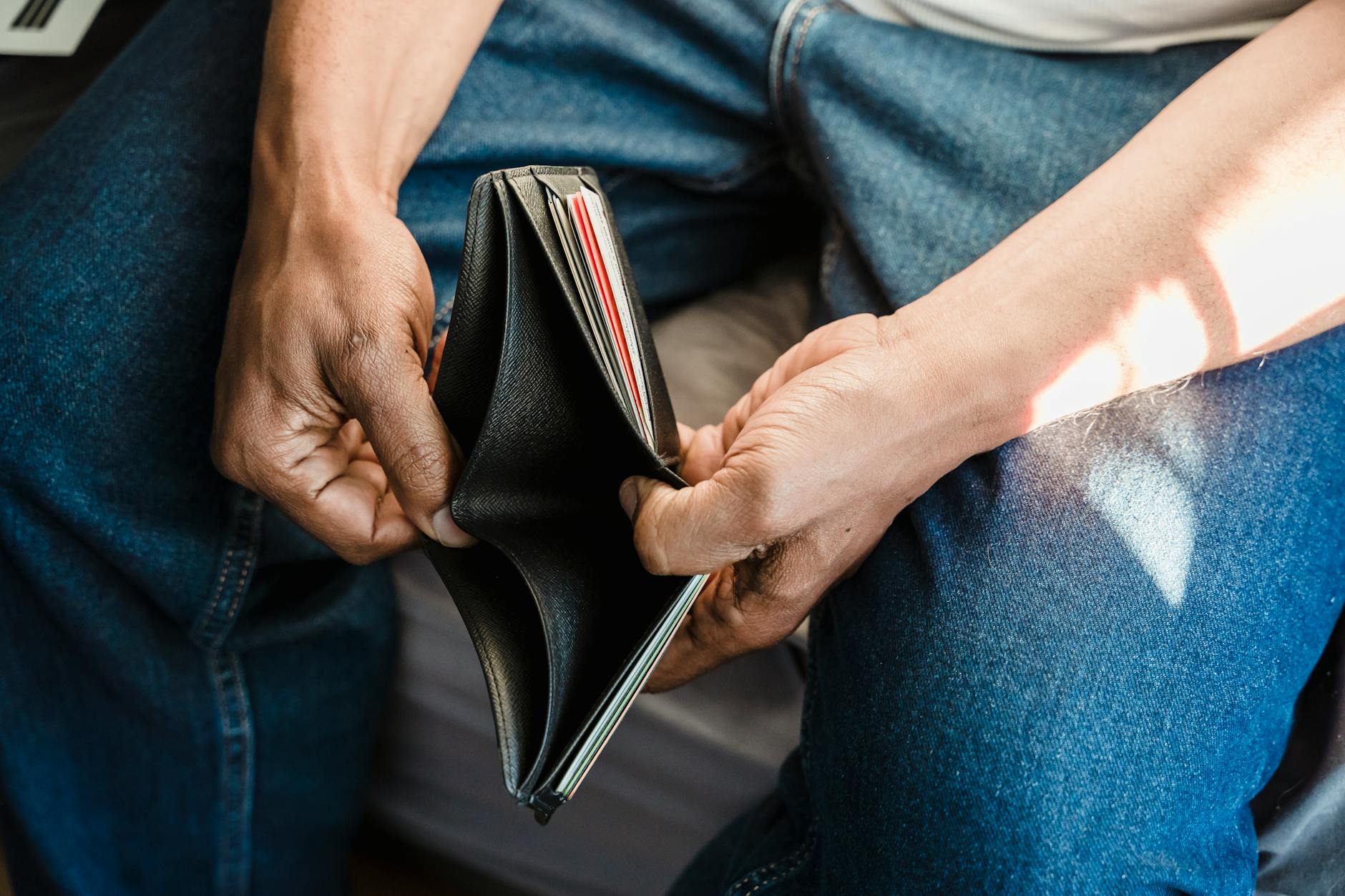 Overwhelmed By Debt? Here's How to Get Through It 13 man looking at an empty wallet Overwhelmed By Debt? Here's How to Get Through It