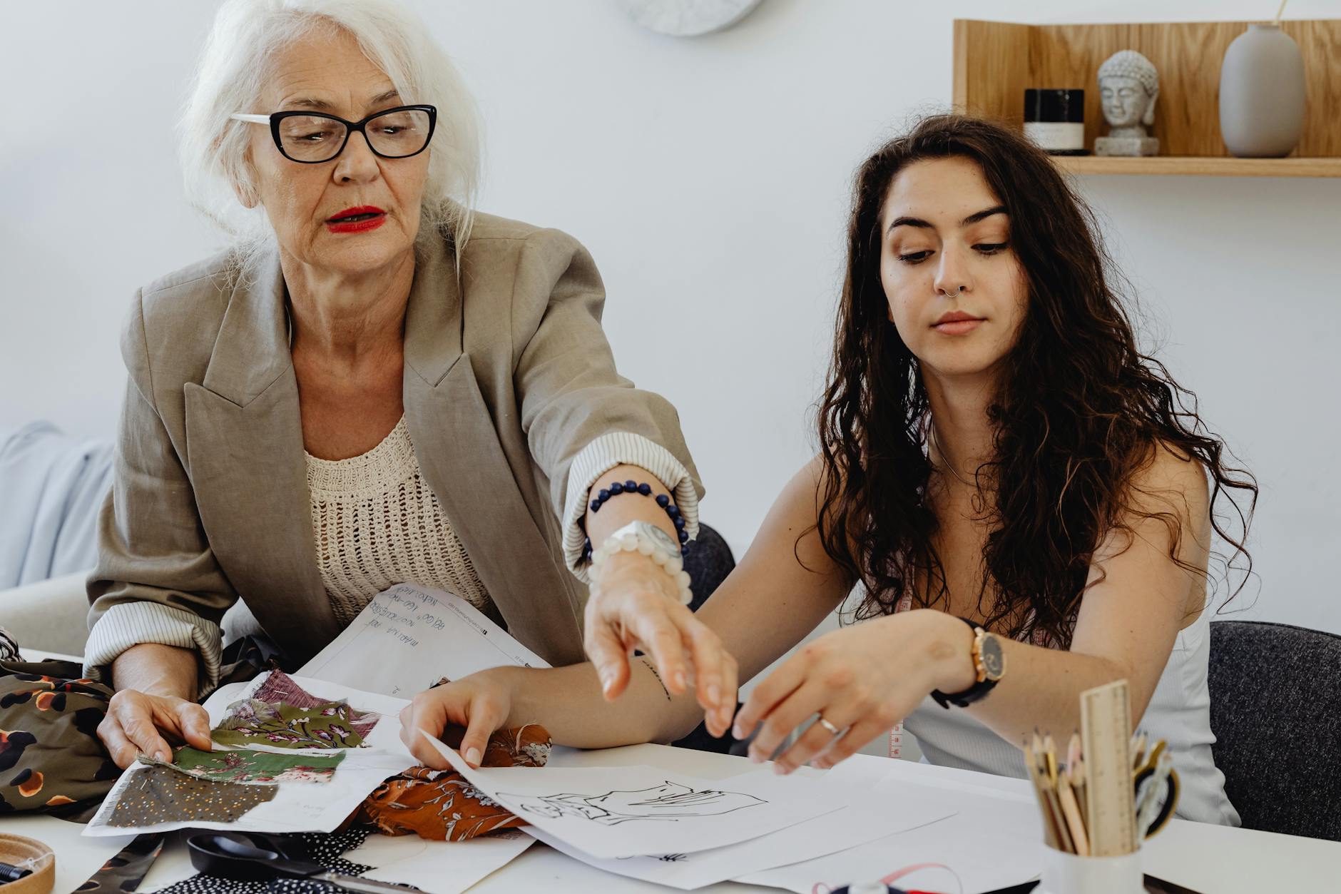 women holding white papers sitting by the table What You Need to Know Before Hiring Family Members